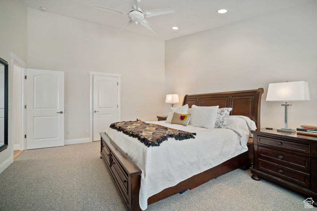 Bedroom with recessed lighting, a high ceiling, a ceiling fan, light carpet, and baseboards