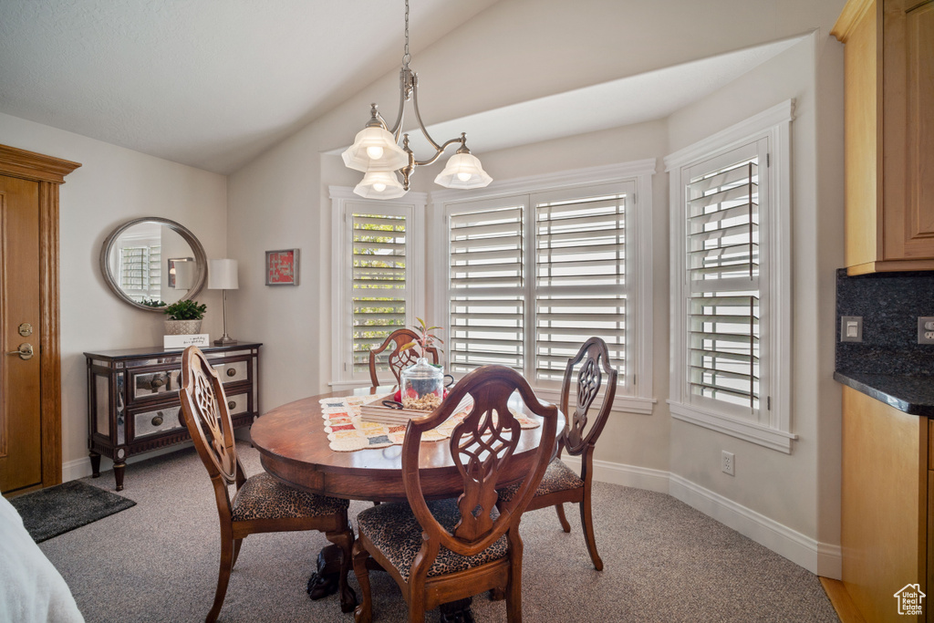 Dining space with light colored carpet, lofted ceiling, and a healthy amount of sunlight