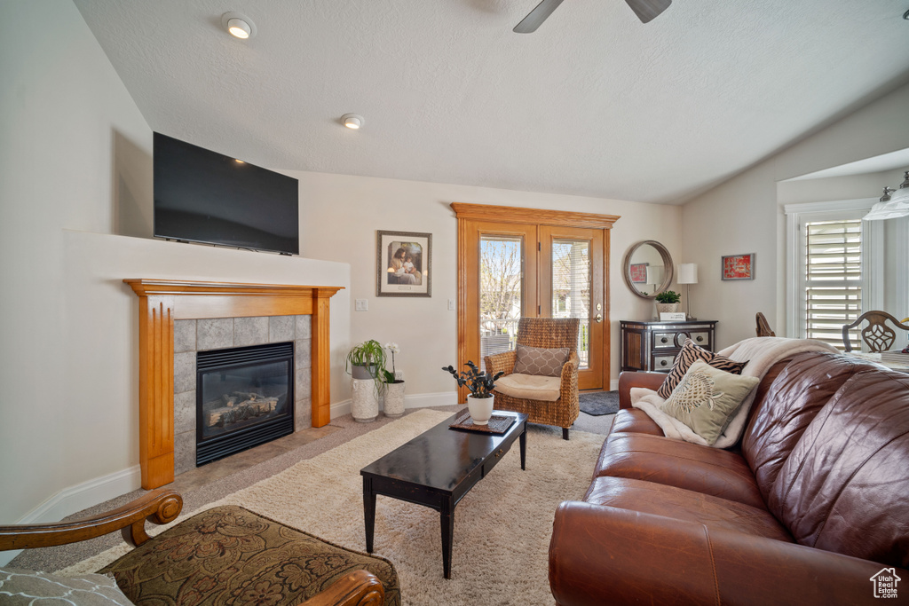 Living area with lofted ceiling, carpet floors, ceiling fan, and a healthy amount of sunlight