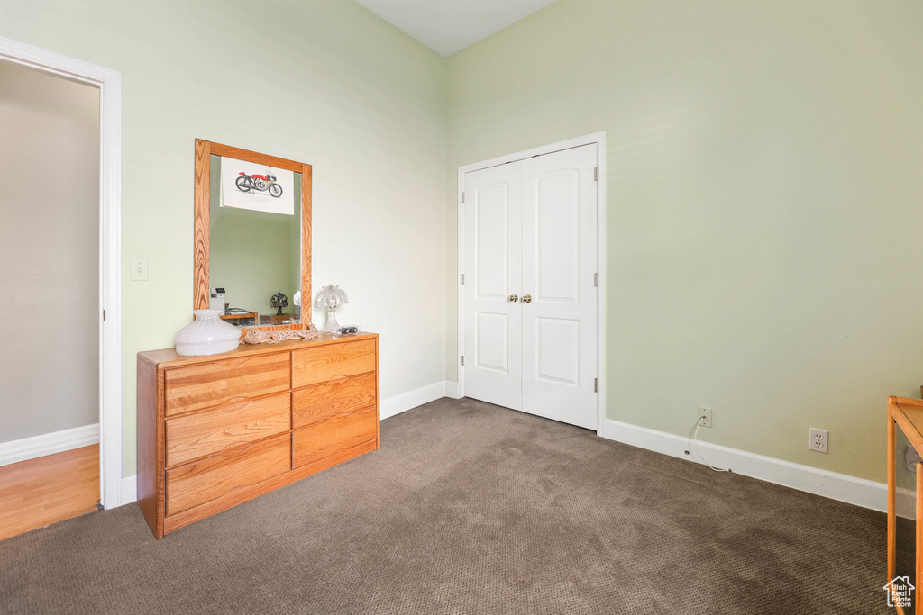 Bedroom with baseboards and dark carpet