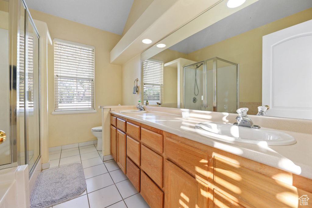 Bathroom featuring a sink, tile patterned flooring, a shower stall, and double vanity