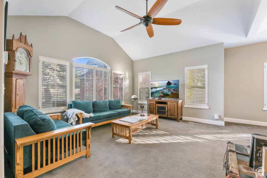Living area with baseboards, a ceiling fan, carpet, and a wealth of natural light