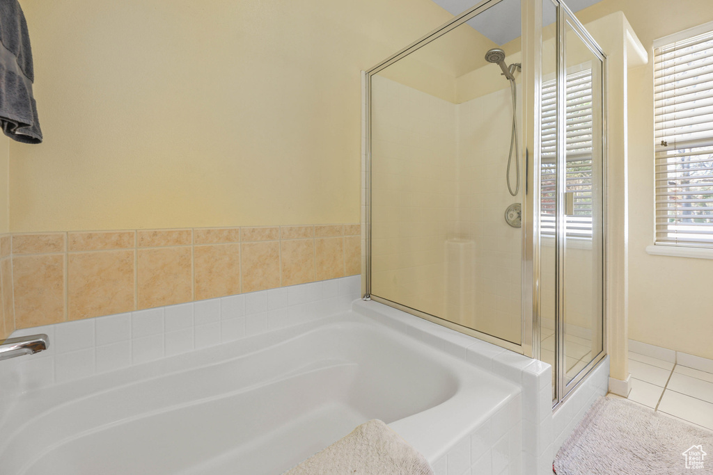 Bathroom with a bath, a shower stall, and tile patterned flooring