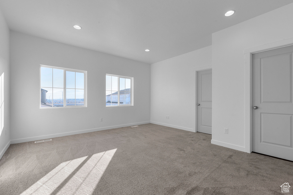 Carpeted spare room featuring visible vents, recessed lighting, and baseboards