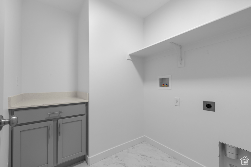 Laundry area with marble finish floor, baseboards, cabinet space, electric dryer hookup, and washer hookup