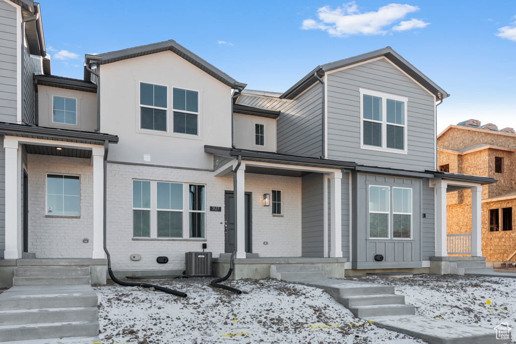 View of front of home featuring brick siding and cooling unit