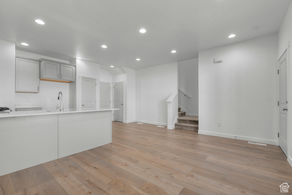 Interior space featuring light countertops, gray cabinets, light wood finished floors, and recessed lighting
