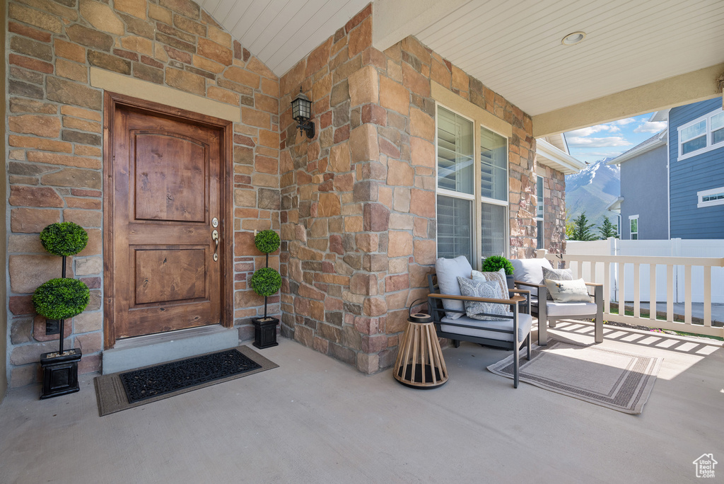 View of exterior entry featuring a mountain view, a porch, and stone siding