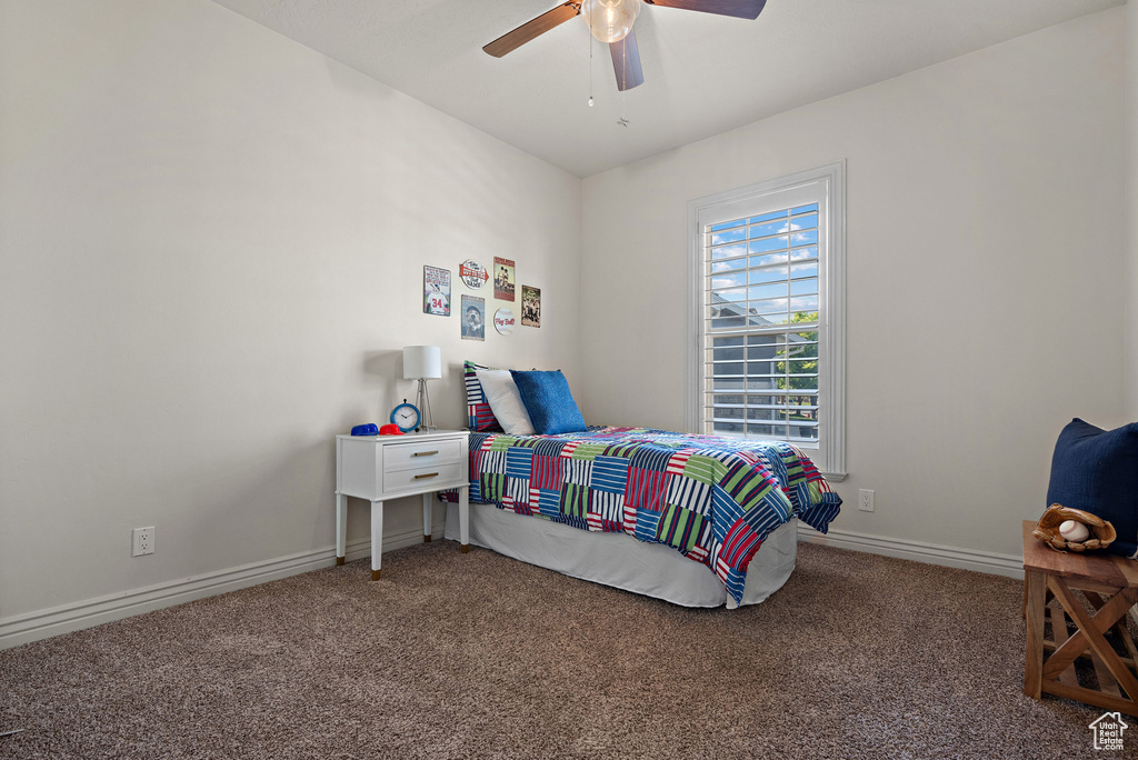 Carpeted bedroom featuring baseboards and ceiling fan