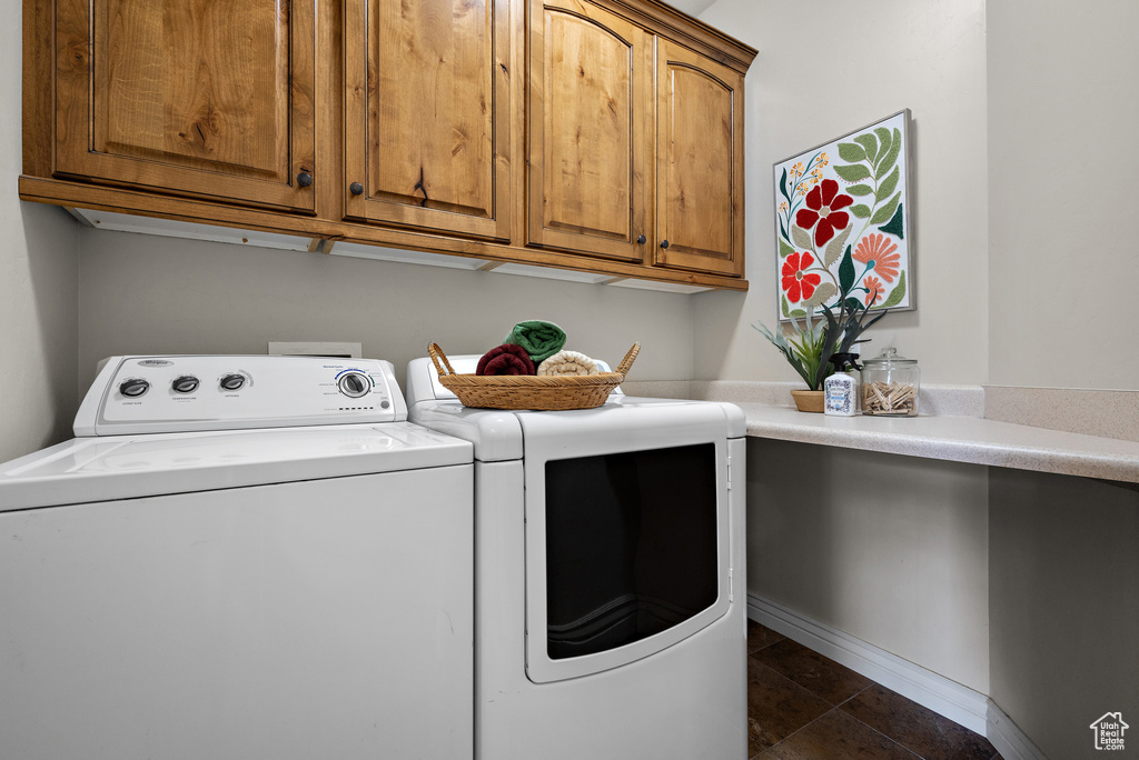 Laundry room with cabinet space, baseboards, and washer and clothes dryer