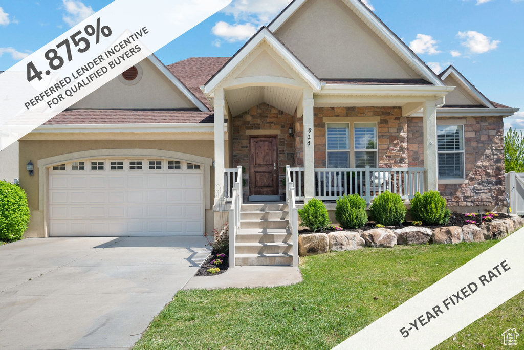 View of front facade featuring stone siding, stucco siding, concrete driveway, an attached garage, and a porch