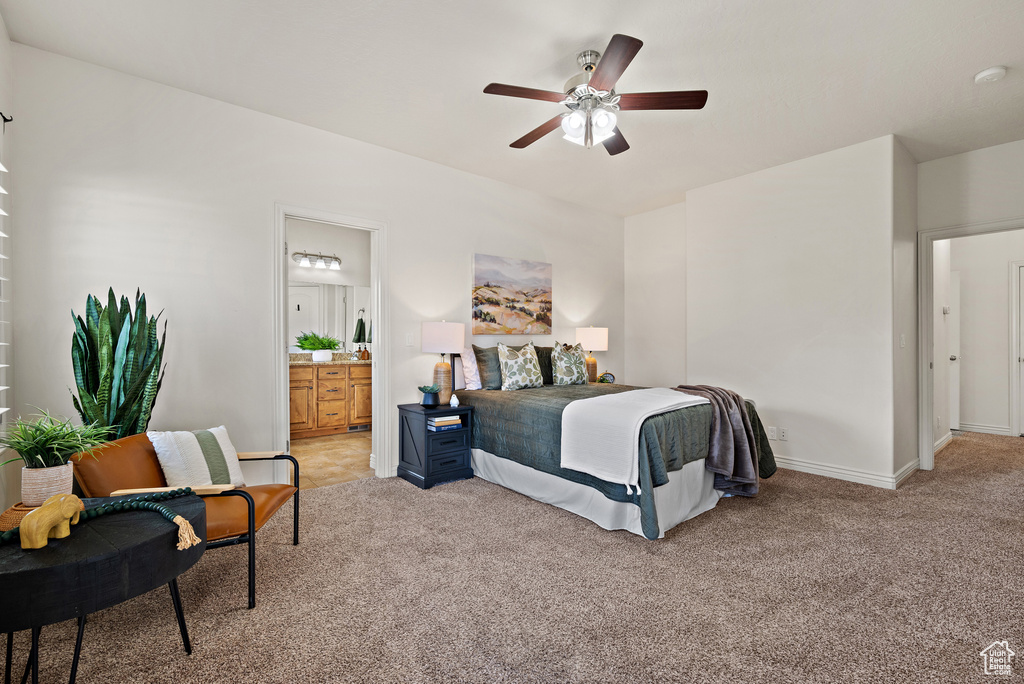 Bedroom with baseboards, light carpet, a ceiling fan, and ensuite bath