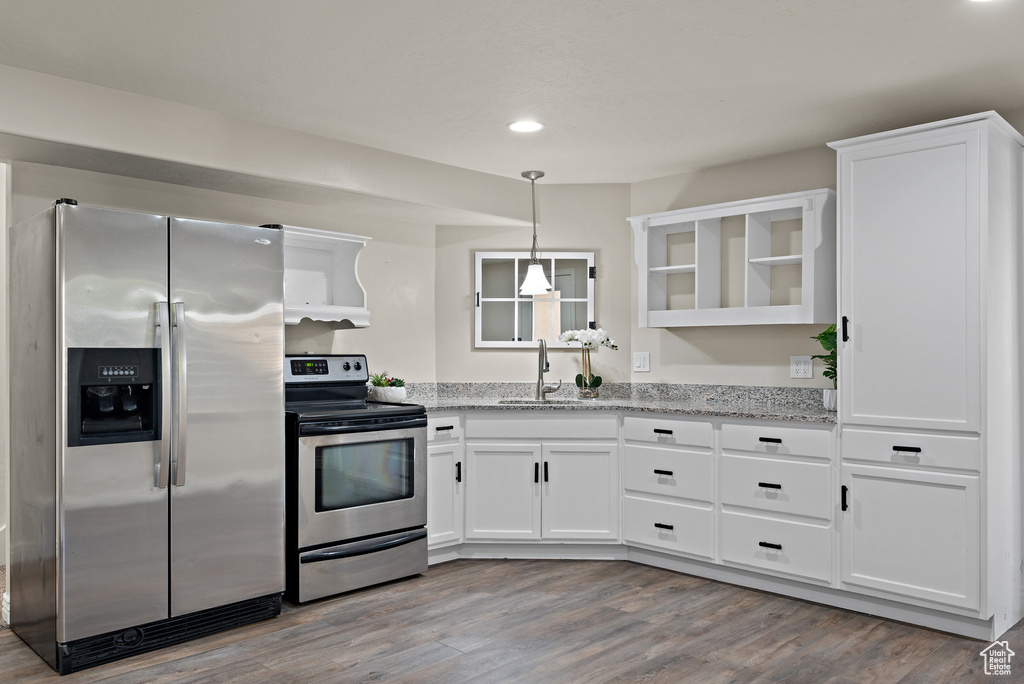 Kitchen featuring a sink, open shelves, stainless steel appliances, and white cabinetry