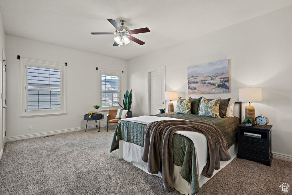 Carpeted bedroom featuring baseboards, ceiling fan, and visible vents