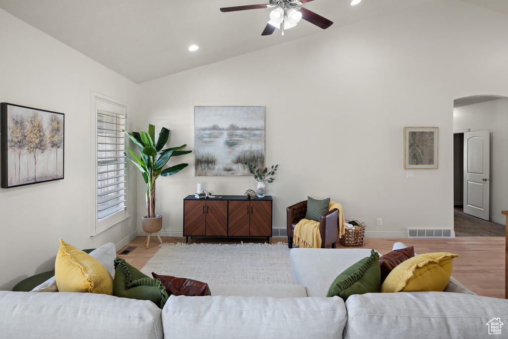 Living area featuring ceiling fan, arched walkways, baseboards, lofted ceiling, and recessed lighting