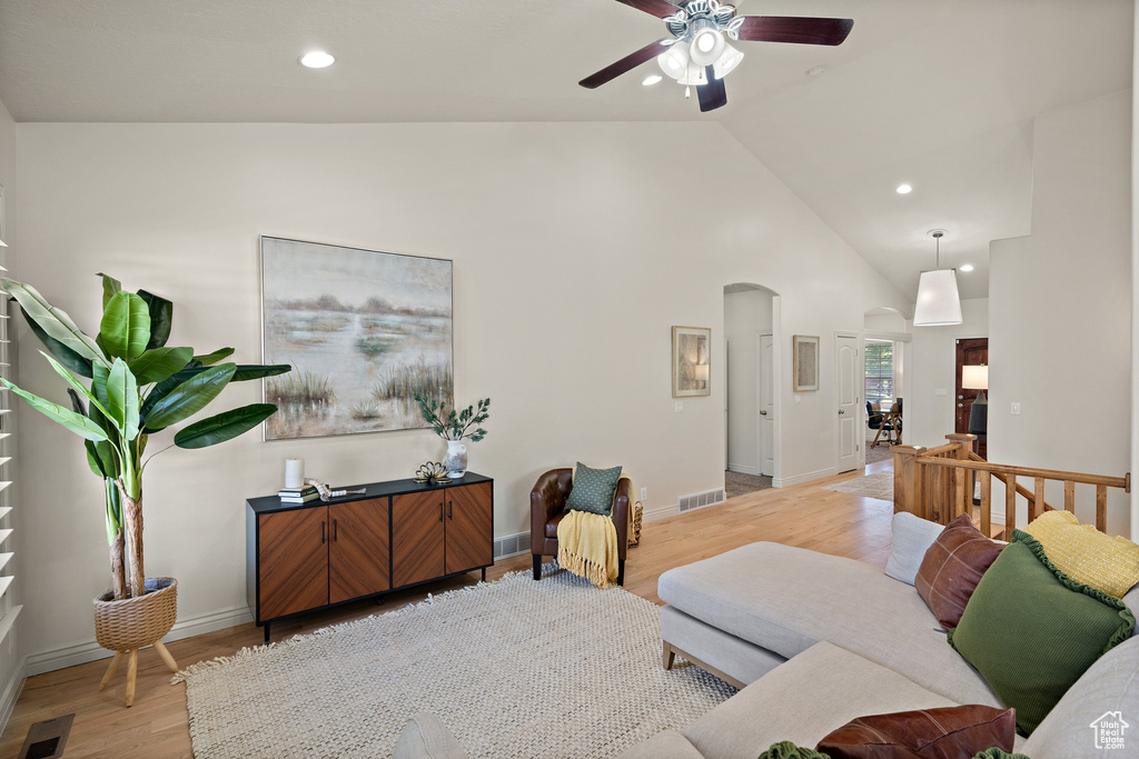 Living area featuring visible vents, light wood-style floors, ceiling fan, recessed lighting, and arched walkways