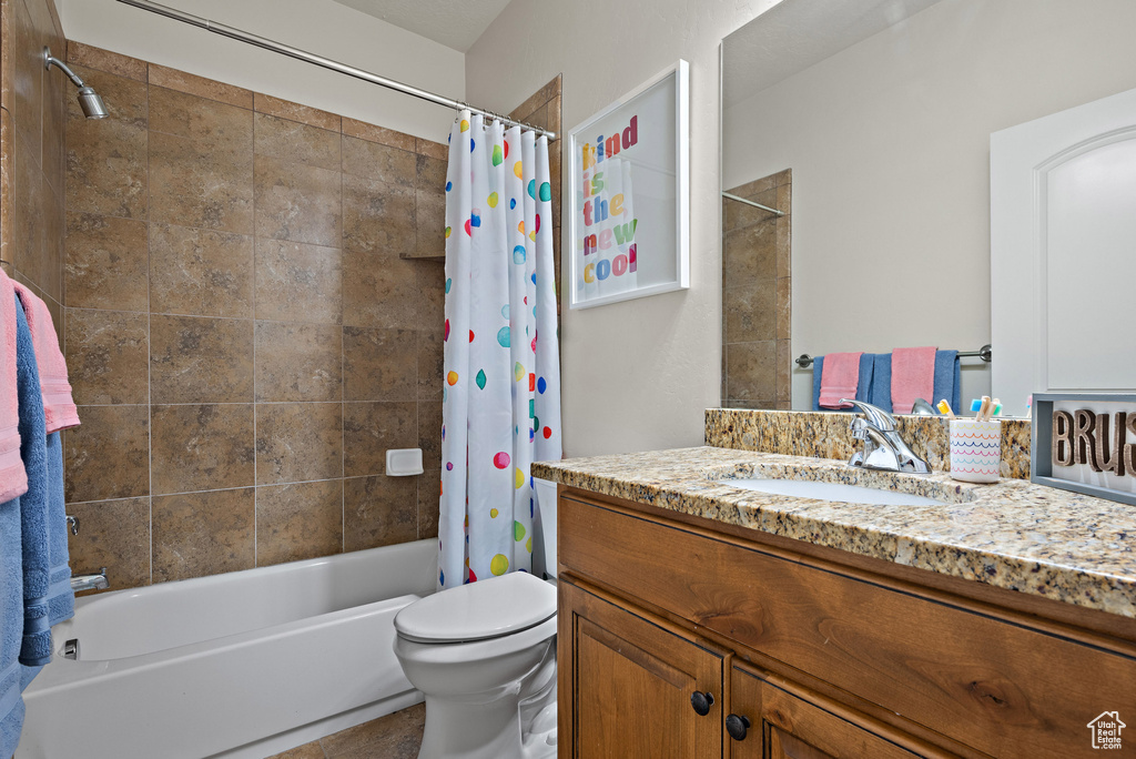 Bathroom with toilet, tile patterned floors, shower / tub combo with curtain, and vanity