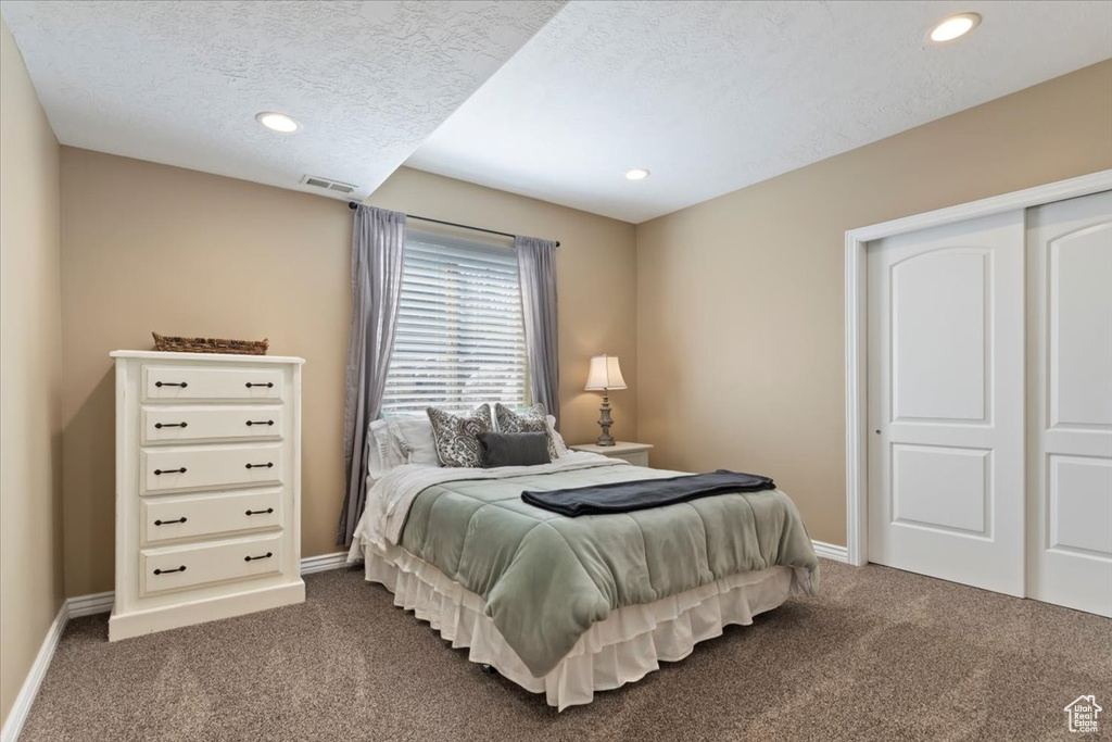 Bedroom featuring recessed lighting, baseboards, dark colored carpet, and visible vents