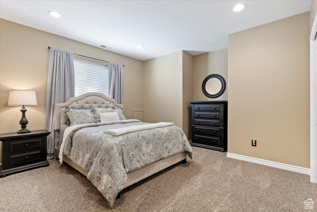 Carpeted bedroom with baseboards, recessed lighting, and visible vents