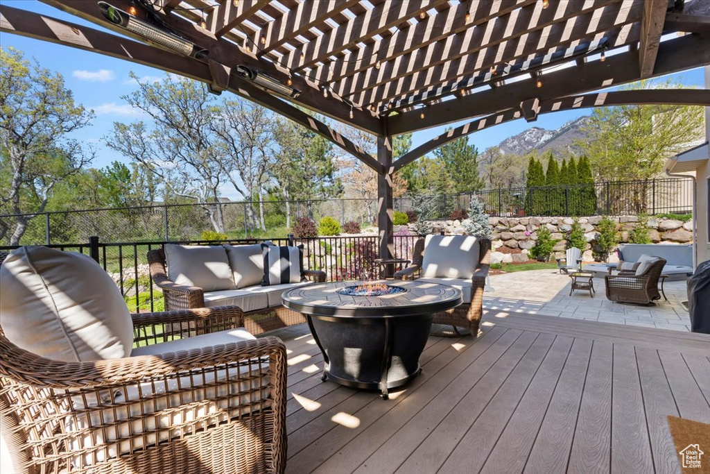 Deck with fence, an outdoor living space with a fire pit, a pergola, and a mountain view
