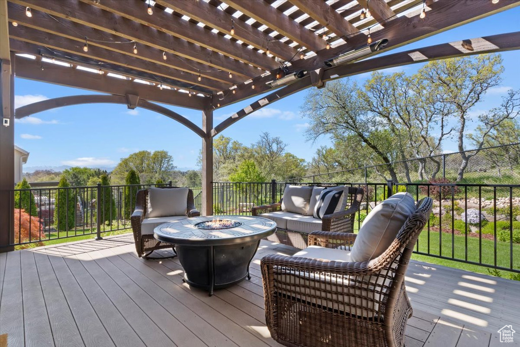 Deck with an outdoor living space with a fire pit and a pergola