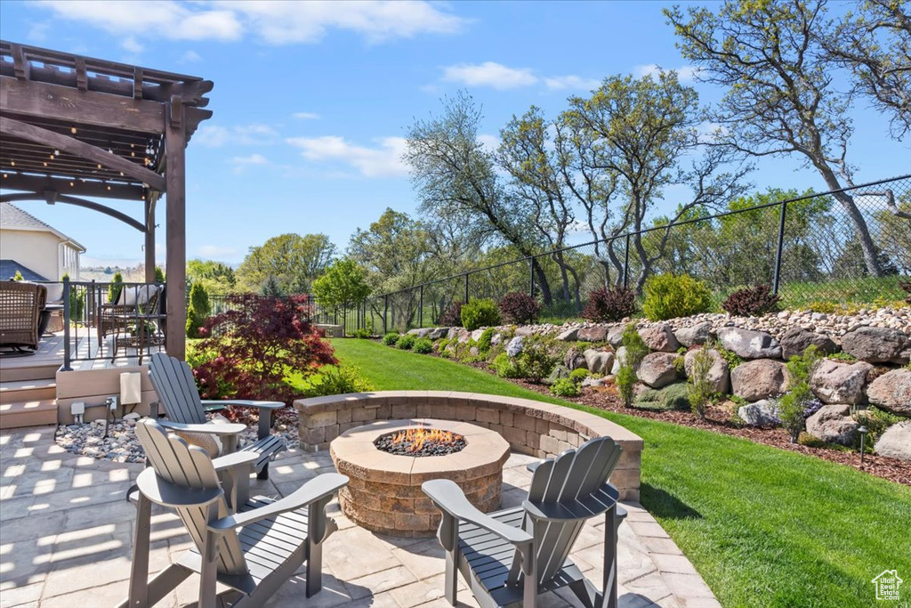 View of patio / terrace with a pergola, fence, and a fire pit