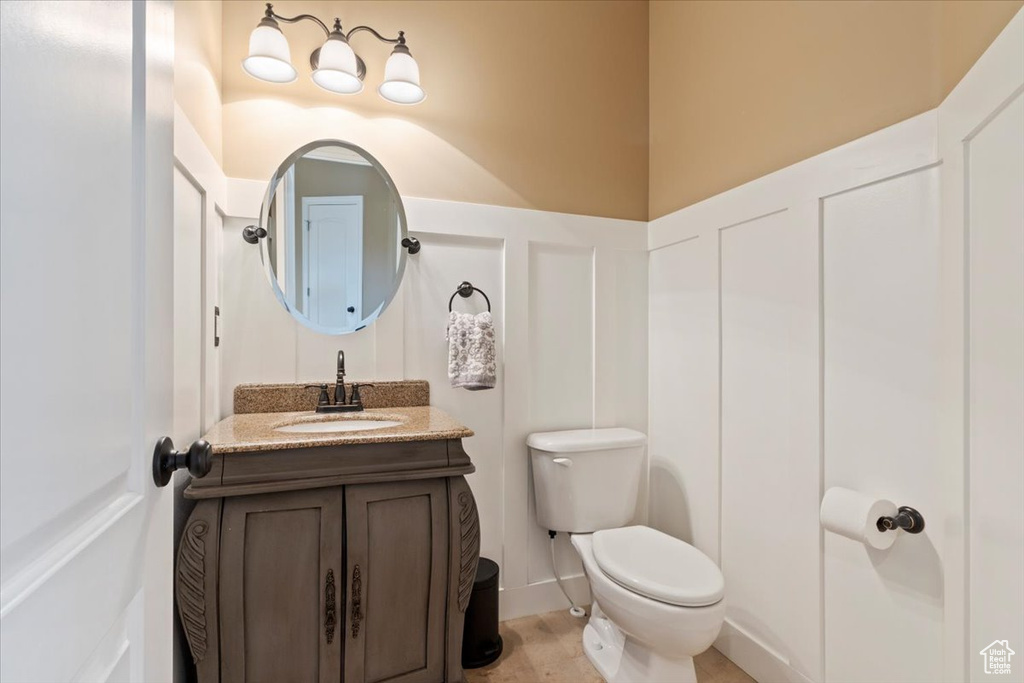 Half bathroom featuring vanity and toilet