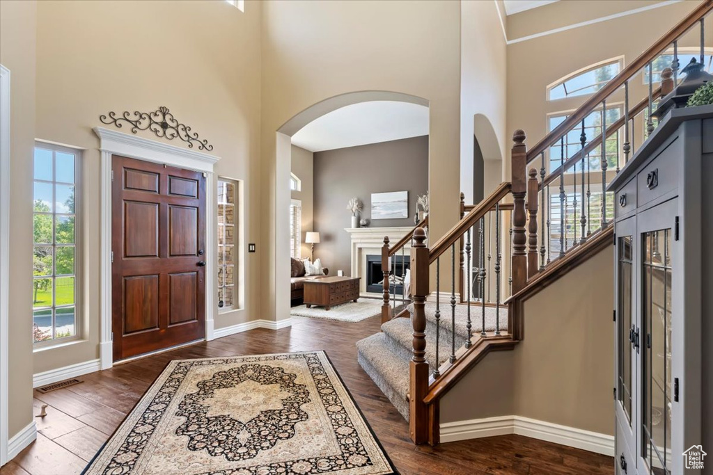 Foyer featuring plenty of natural light, baseboards, and a towering ceiling