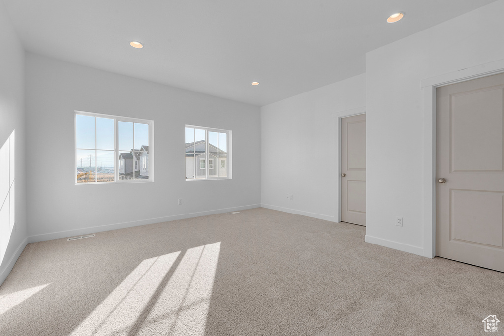 Unfurnished room with baseboards, light carpet, and recessed lighting