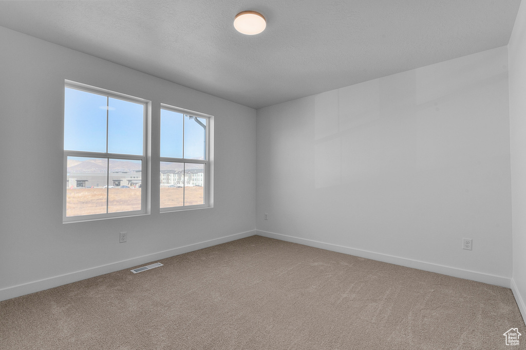 Spare room with baseboards, carpet, and visible vents