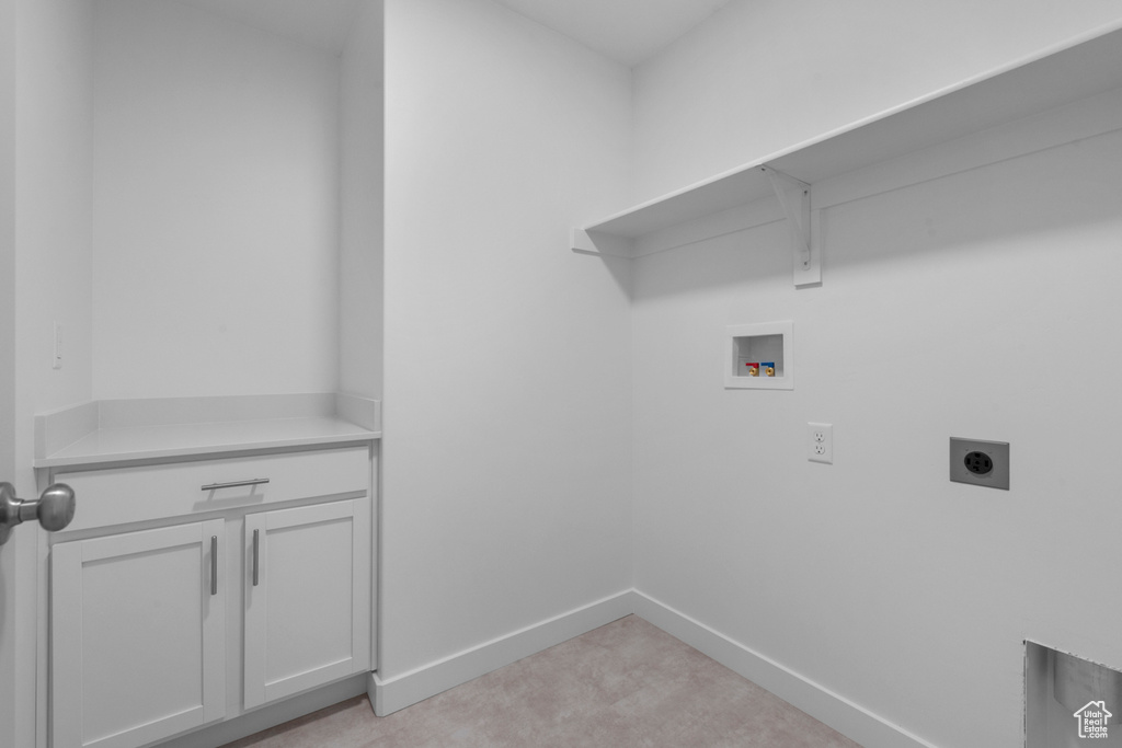 Laundry area with washer hookup, electric dryer hookup, light colored carpet, cabinet space, and baseboards