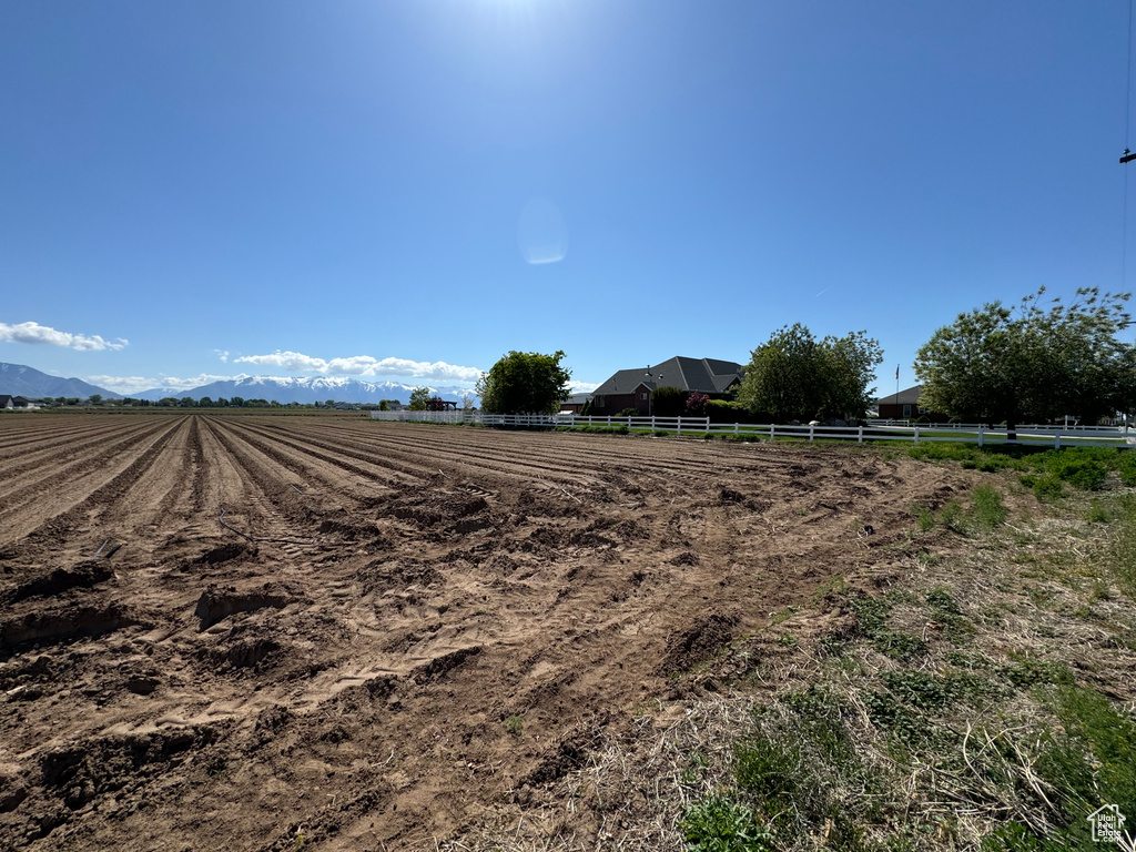 View of yard with a rural view and fence