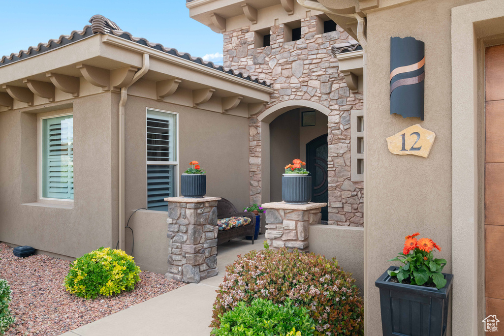 View of exterior entry featuring stucco siding and stone siding