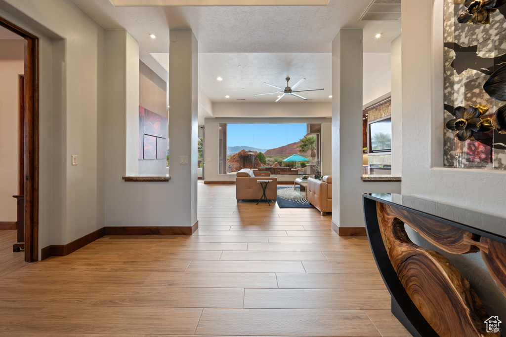 Hallway with baseboards, recessed lighting, and wood finished floors