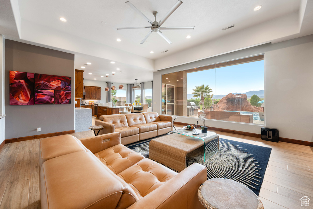 Living room featuring baseboards, recessed lighting, light wood-style floors, and ceiling fan