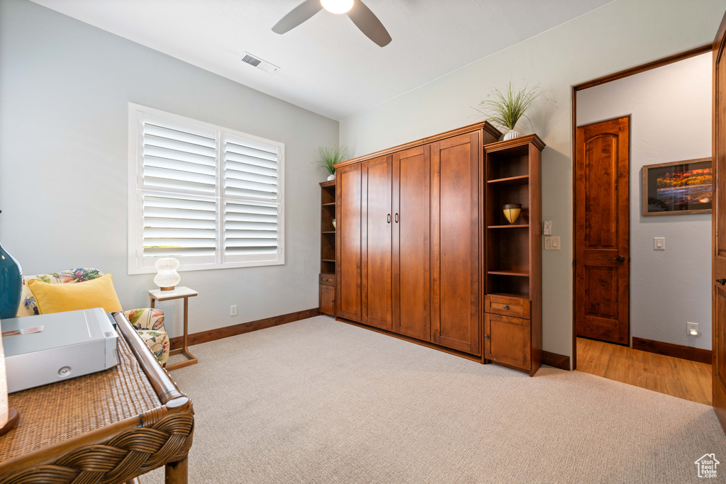 Bedroom with baseboards, visible vents, light carpet, and ceiling fan