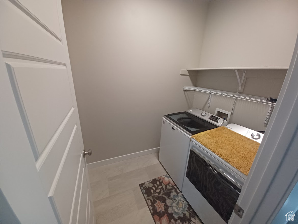 Clothes washing area with washing machine and dryer and baseboards