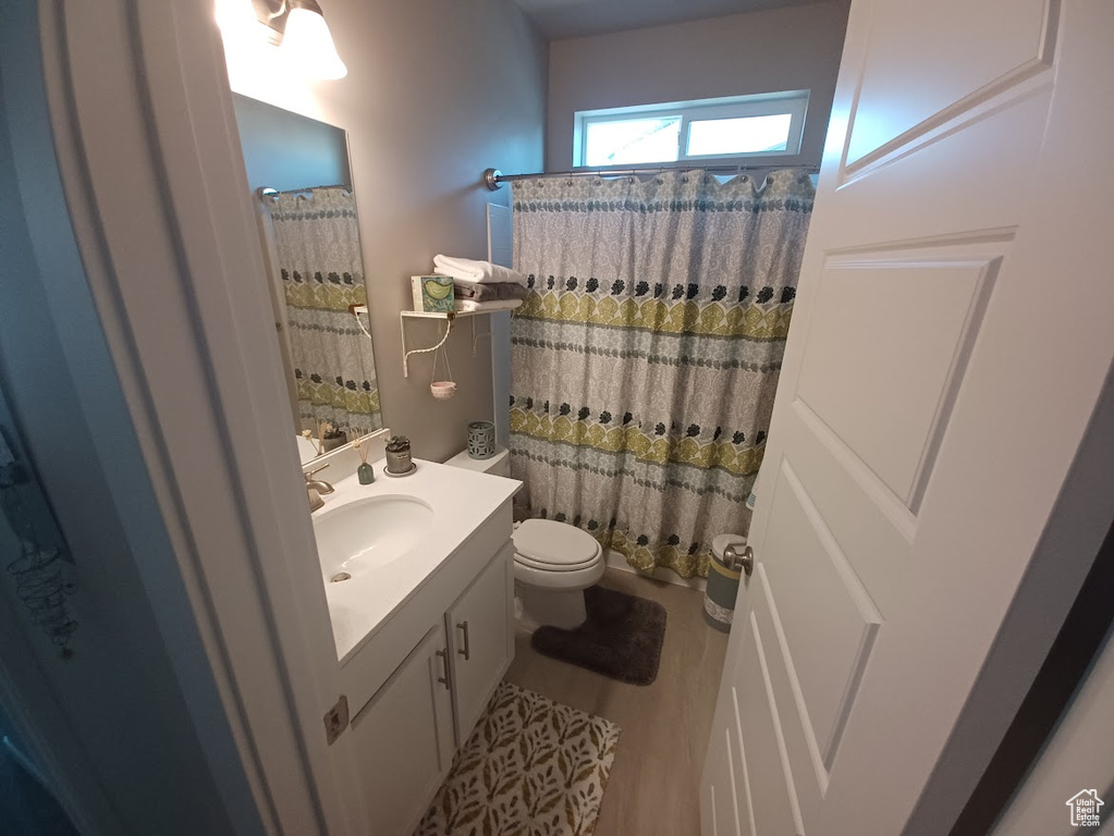 Full bath with vanity, toilet, and a shower with shower curtain