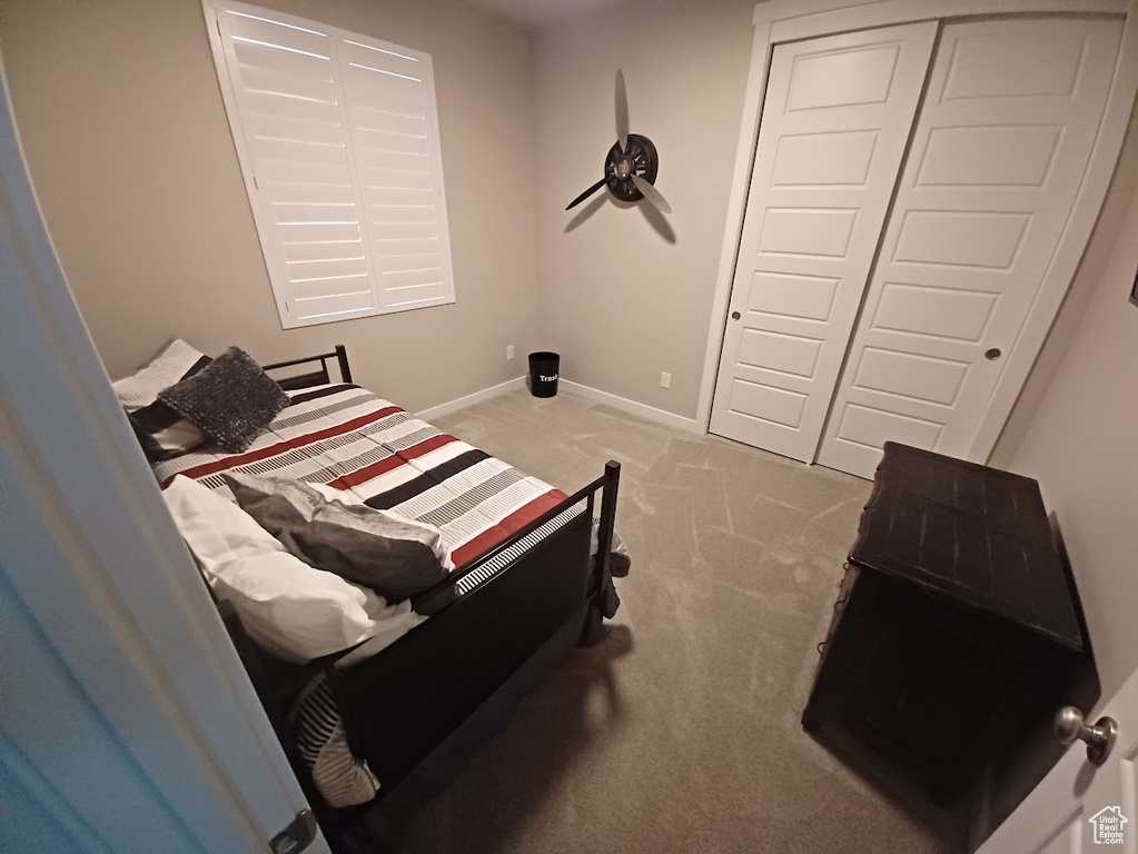 Carpeted bedroom with a closet and baseboards