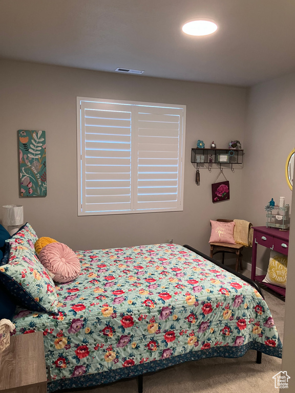 Carpeted bedroom featuring baseboards and visible vents