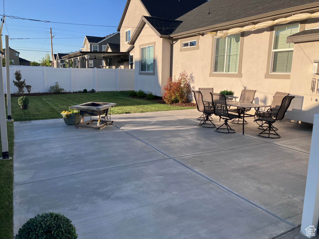 View of patio with a fire pit and outdoor dining area