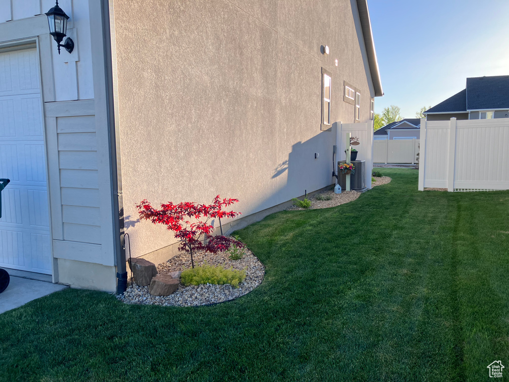 View of home's exterior with stucco siding and central AC unit
