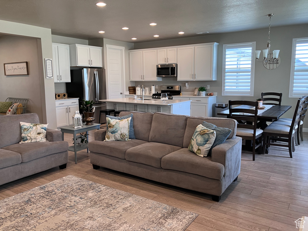Living area featuring a chandelier, light wood finished floors, and recessed lighting