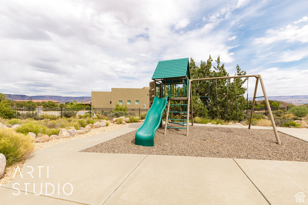 Community playground with fence and a mountain view