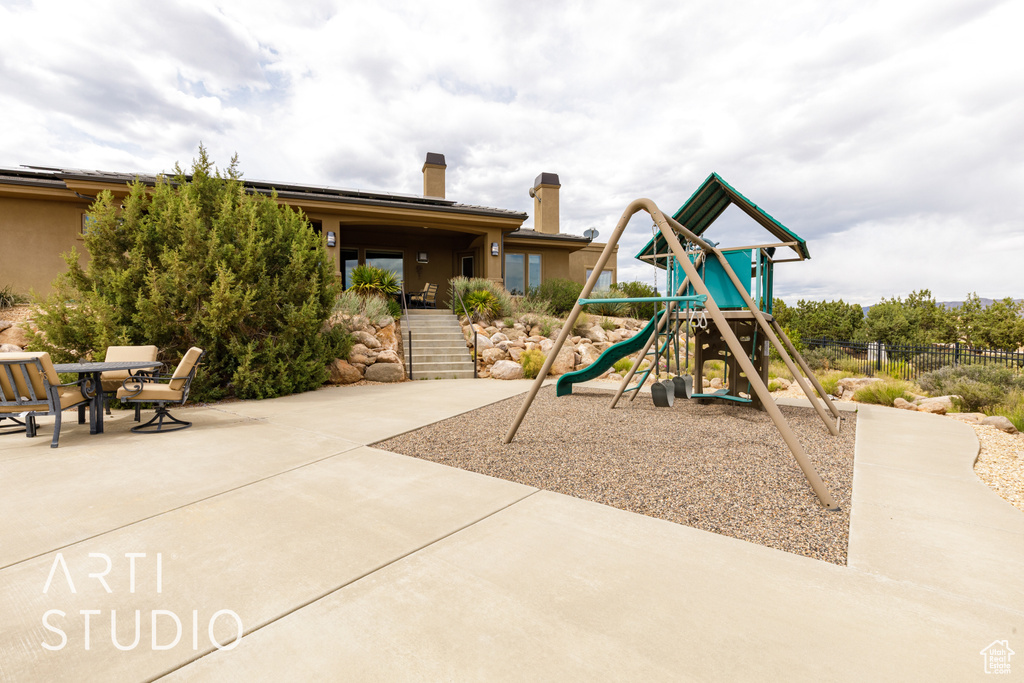 Community playground featuring a patio and fence