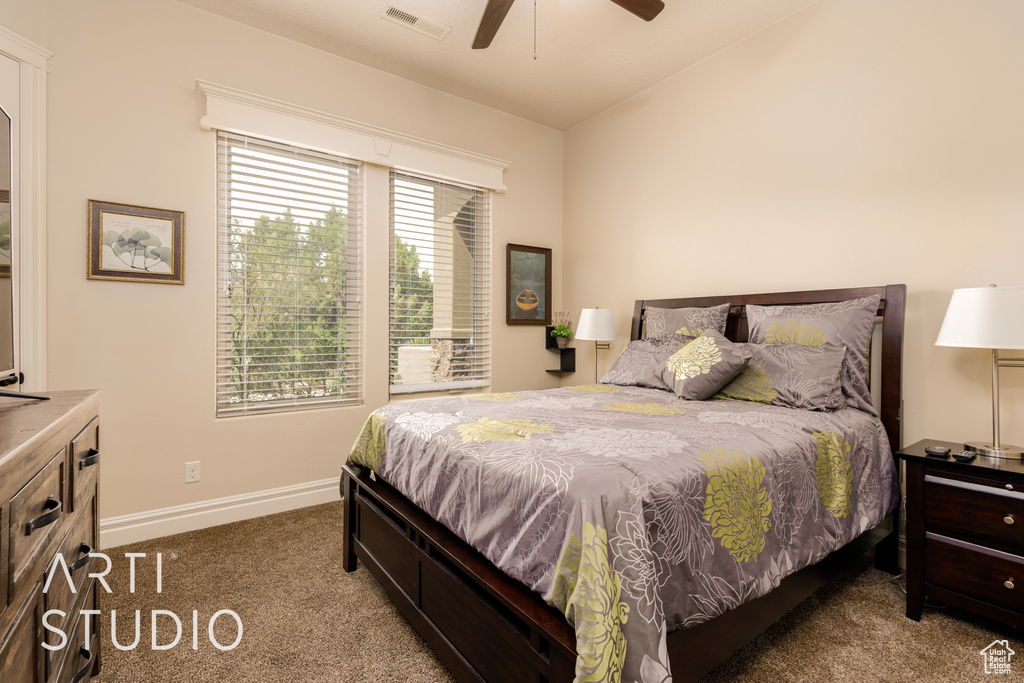 Bedroom with ceiling fan, carpet, baseboards, vaulted ceiling, and visible vents