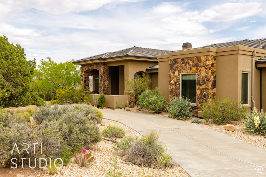 View of front facade featuring stucco siding and stone siding