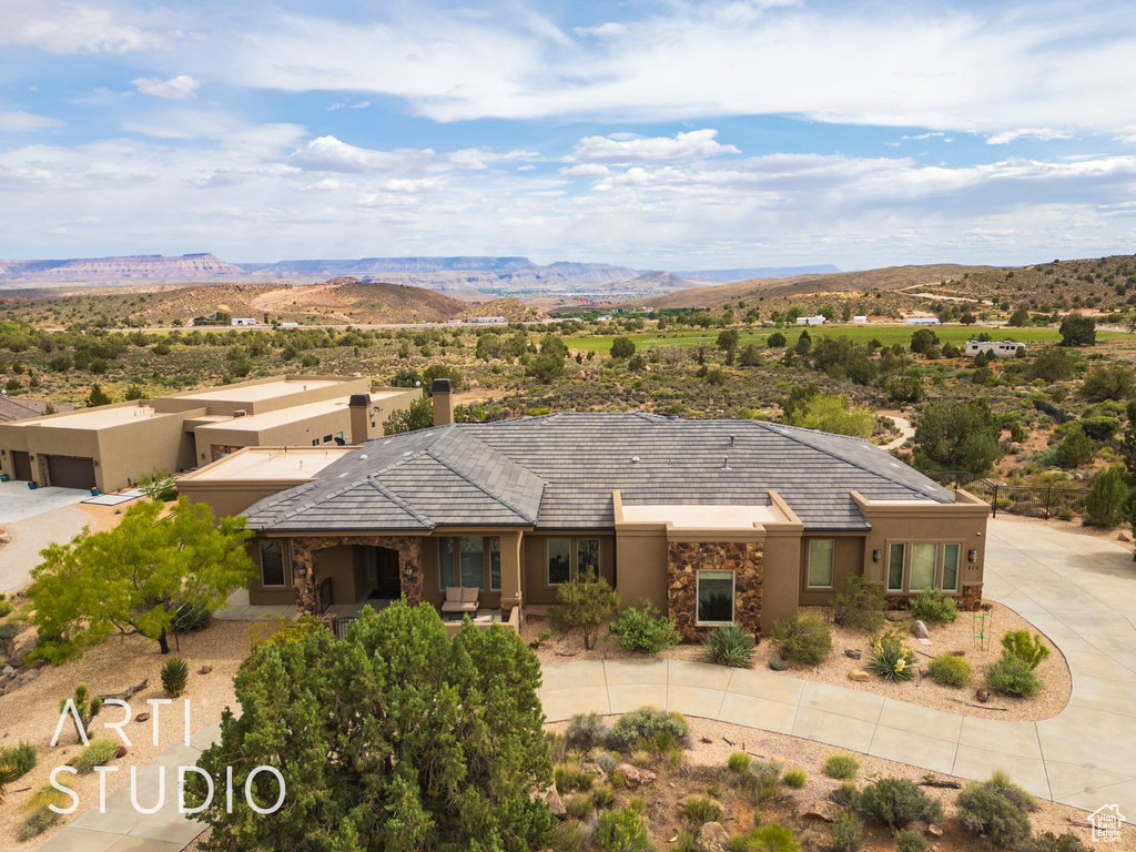 Ranch-style home featuring a mountain view, stone siding, and stucco siding