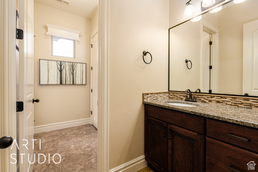 Bathroom featuring baseboards, visible vents, tile patterned floors, and vanity