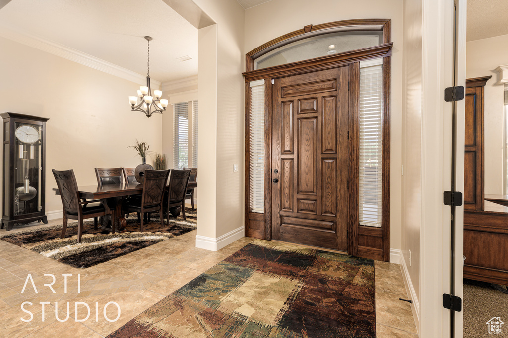 Entrance foyer featuring baseboards, ornamental molding, and a notable chandelier